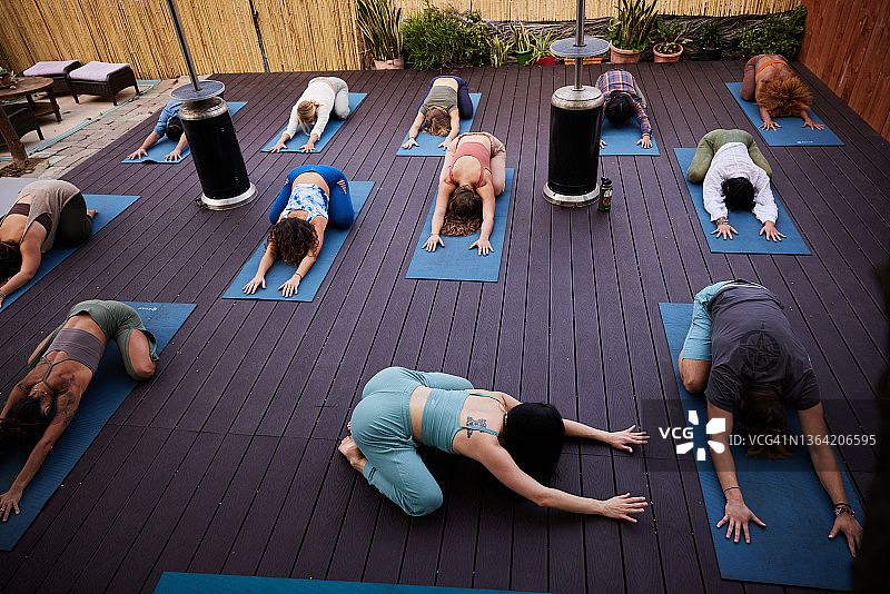 瑜伽教练在户外课堂上与学生一起做儿童式瑜伽图片素材
