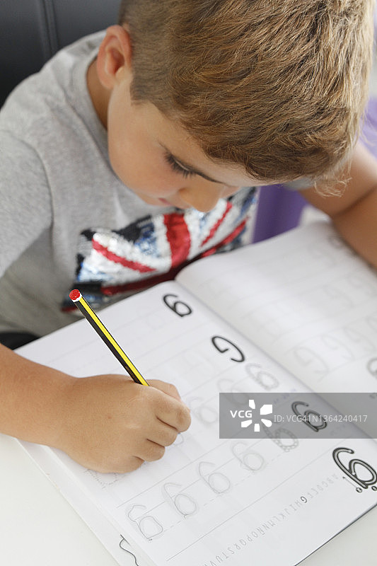 小男孩学习写字的特写图片素材