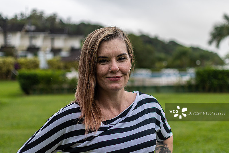 房子外，一个侧发微笑的女人图片素材