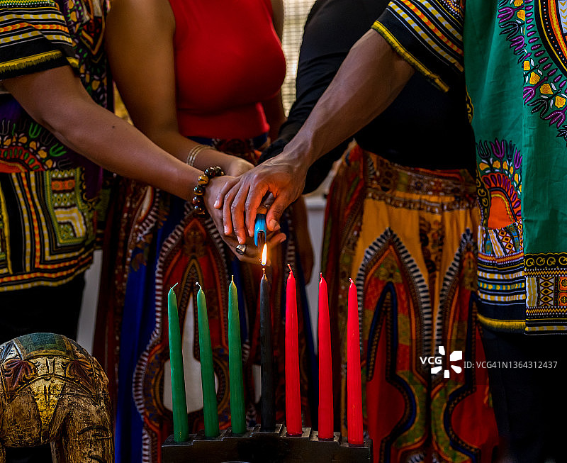 宽扎节庆祝活动：家人点燃团结精神的基纳拉蜡烛图片素材