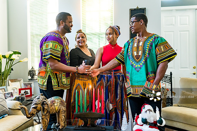 宽扎节庆祝活动，非裔美国家庭在家中一起举着团结杯图片素材