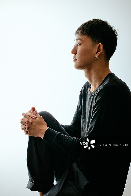 抱着膝盖的冲浪者侧面照图片素材