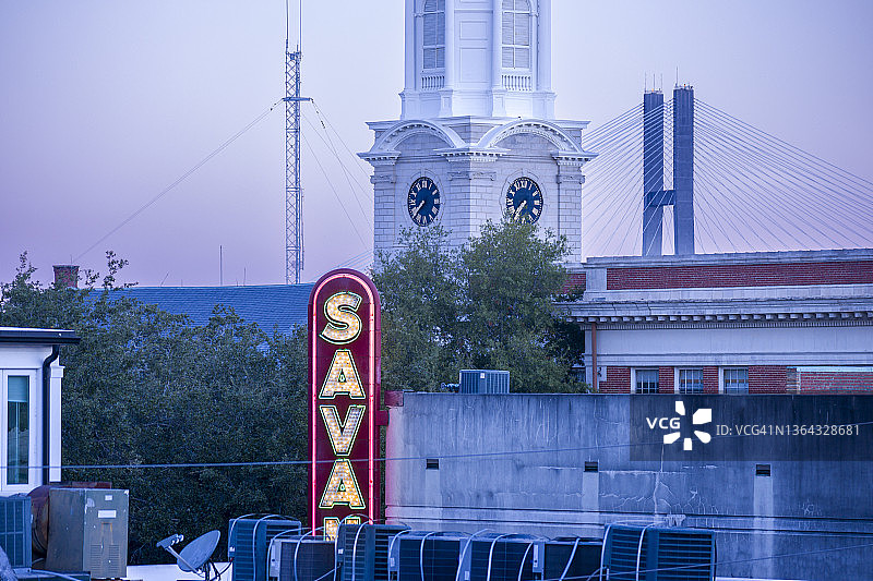 暮色下的塔尔马奇大桥、主教教堂尖顶和萨凡纳剧院标志的屋顶景观图片素材