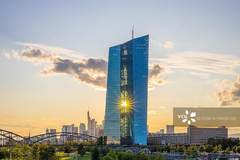 金色时段的欧洲中央银行（ECB），阳光反射在玻璃幕墙上，阳光从伊格纳茨·布比斯桥照射，德国黑森州法兰克福图片素材