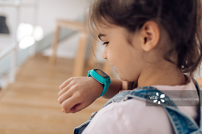 小女孩在家使用智能手表图片素材