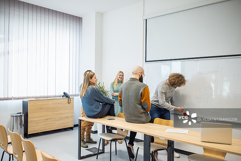 学生在白板上向同事讲解作业图片素材