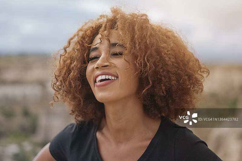 微笑的卷发年轻女子肖像图片素材