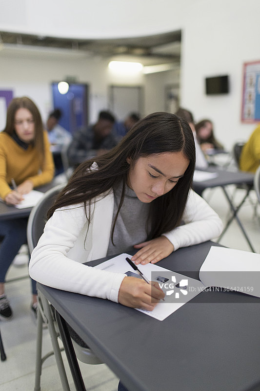 女高中生在教室课桌前考试图片素材