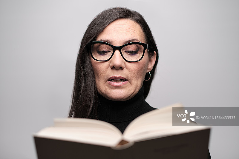 女人大声朗读一本大书图片素材