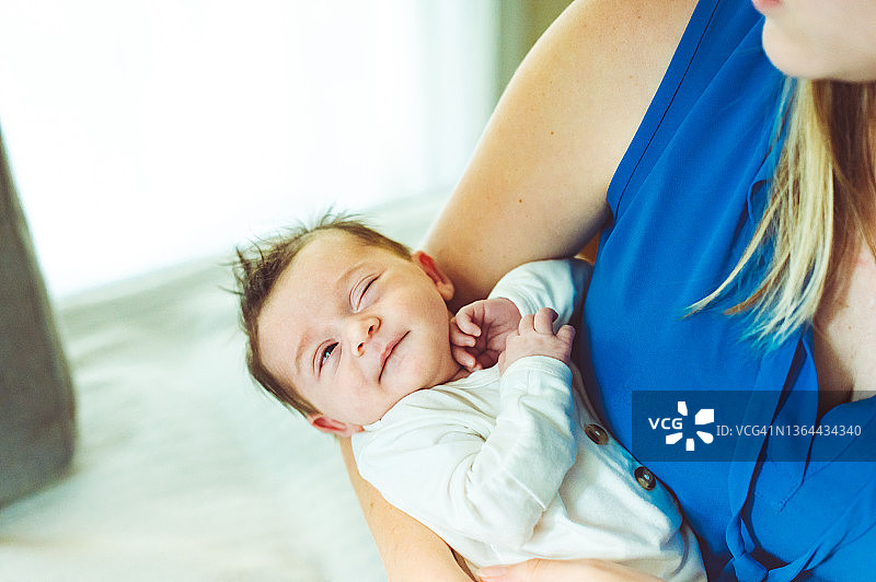 新生婴儿用有趣的表情，像表情包一样怀疑地看着妈妈图片素材