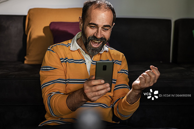中年男人在手机上查看博彩结果图片素材