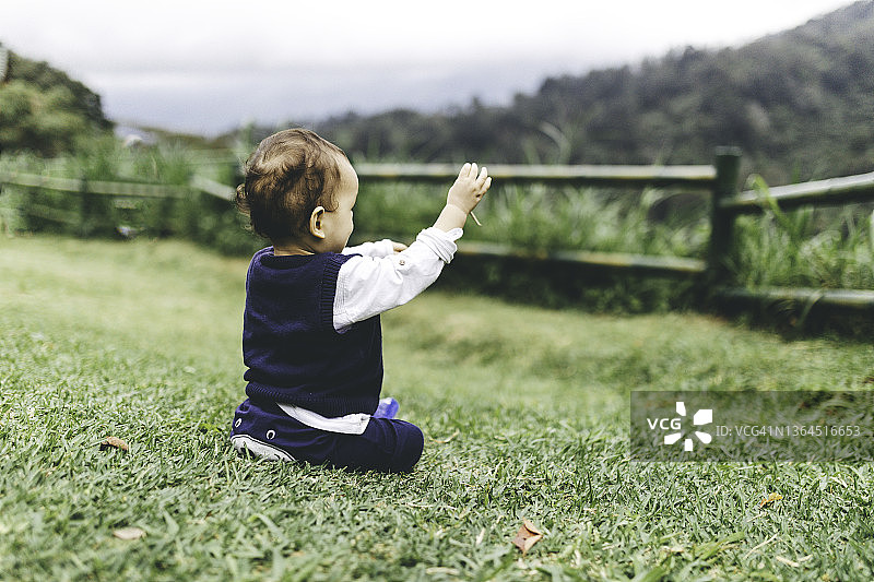 在春天草坪上玩耍奔跑的男婴图片素材