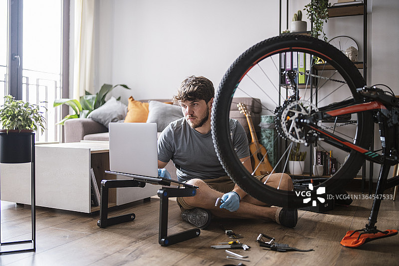 男人使用科技产品修理自行车图片素材