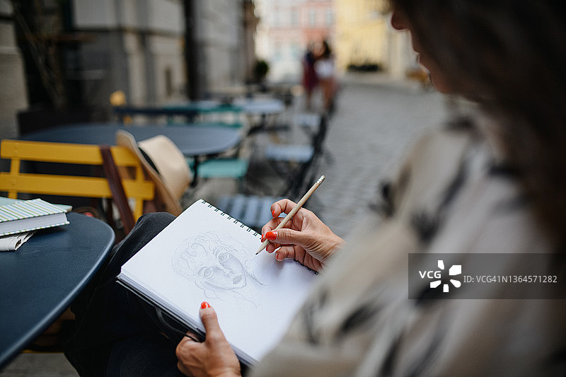 女艺术家在咖啡馆户外作画图片素材