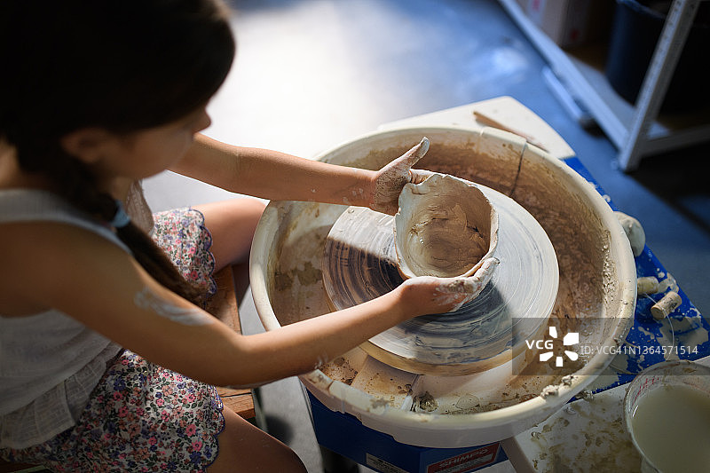 艺术工作室里专心制作陶器的小女孩的高角度视图图片素材