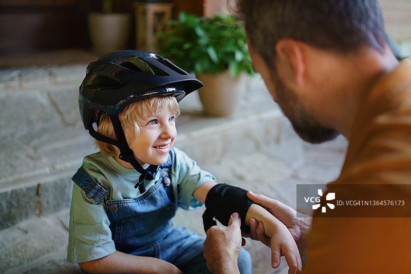 年长的男人为儿子第一次户外骑自行车做准备图片素材