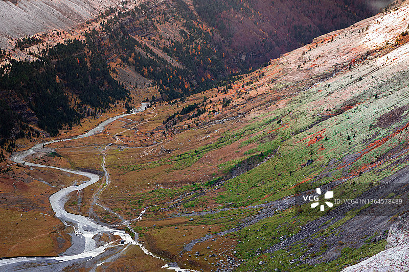 西班牙比利牛斯山脉的蜿蜒河流，呈现秋色和雪景图片素材