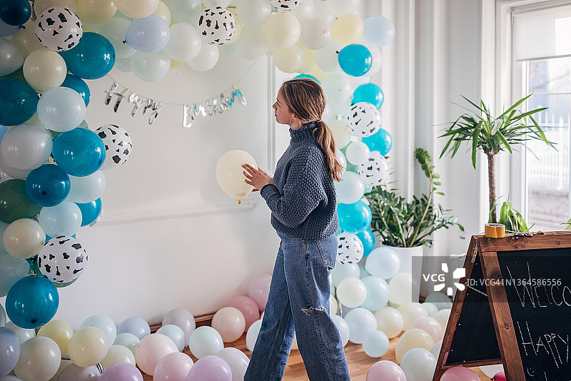 年轻的派对策划师正在布置气球装饰图片素材