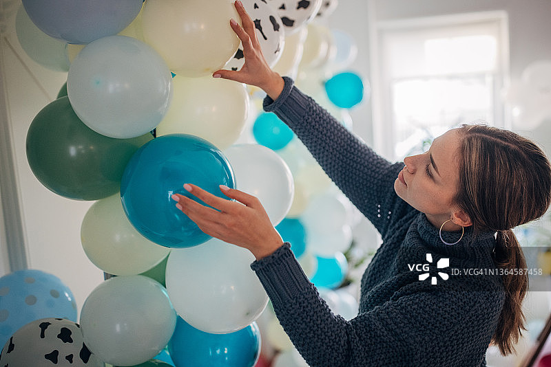 年轻的派对策划师正在布置气球装饰图片素材