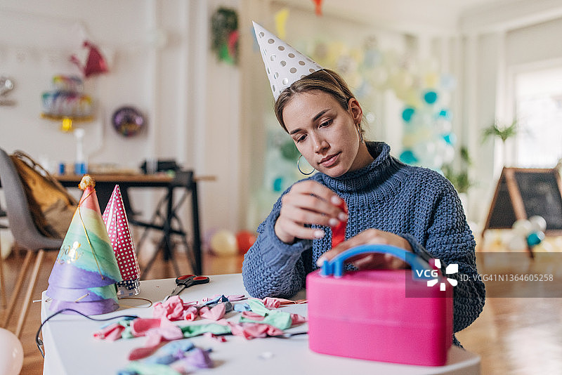 年轻的派对装饰员用气球泵吹气球图片素材