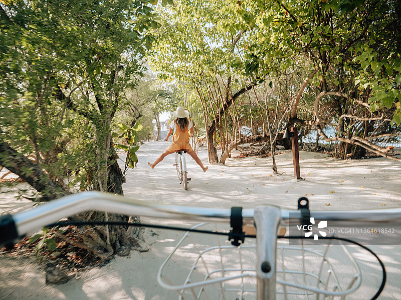 情侣在热带岛屿上骑自行车的POV视角图片素材