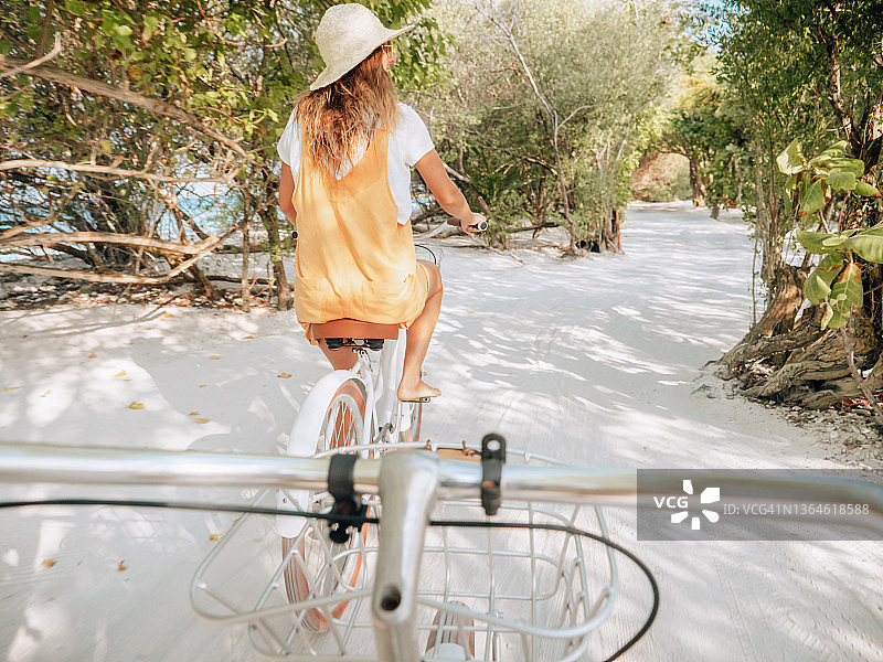 情侣在热带岛屿上骑自行车的POV视角图片素材