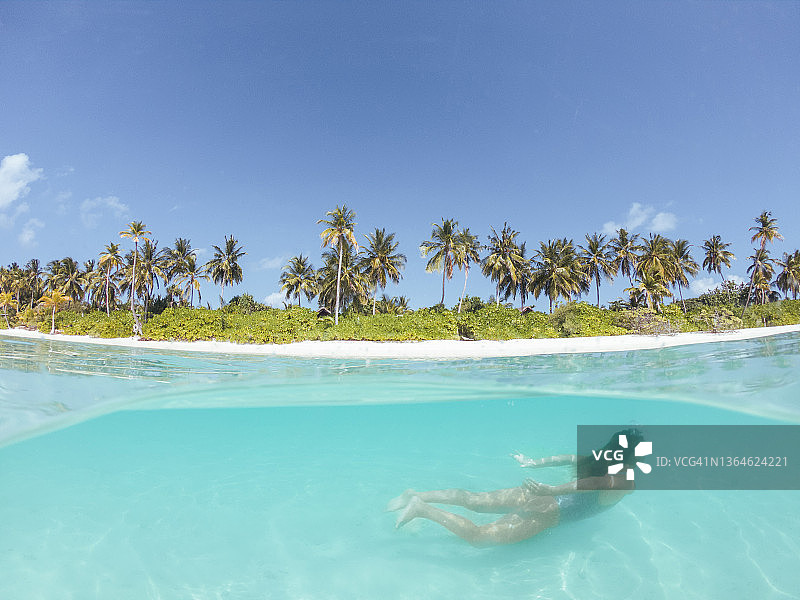 女子在热带海洋中潜水，水下分屏拍摄图片素材