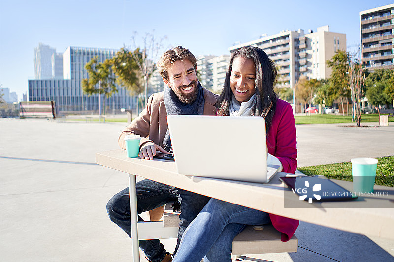 年轻的跨种族创业情侣在户外使用电脑图片素材