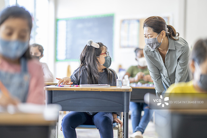 老师戴口罩一对一辅导学生图片素材