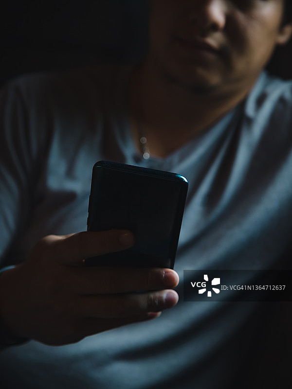 在沙发上使用手机的亚洲青年图片素材