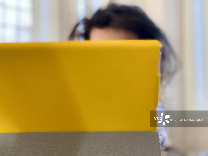 使用明黄色外壳数字平板电脑的混血女孩图片素材