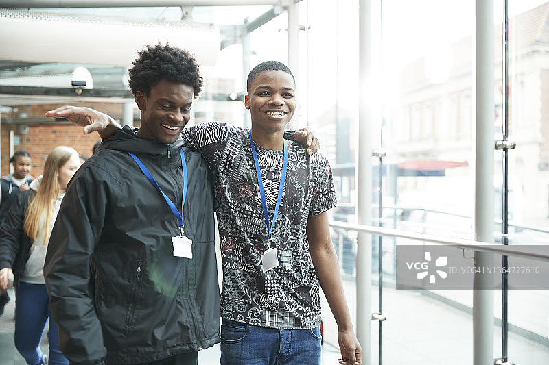 快乐的高中男生朋友在走廊里行走图片素材