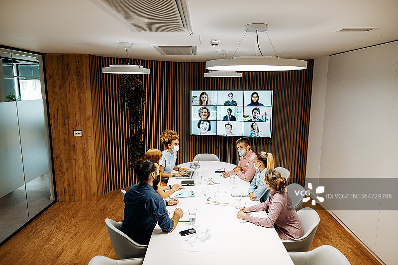 商务人士在办公室参加视频会议，佩戴口罩图片素材