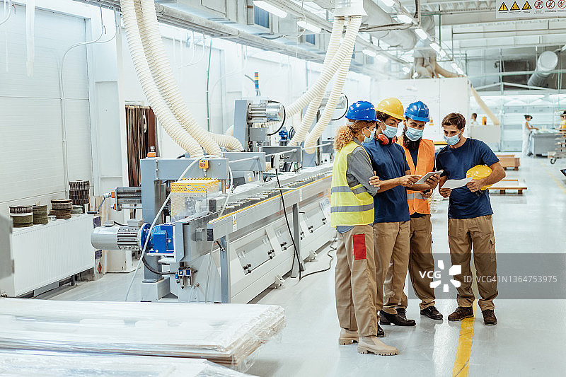 员工在工厂会议期间佩戴口罩图片素材