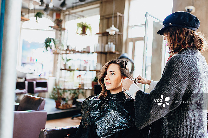 理发店内，理发师为顾客染发图片素材