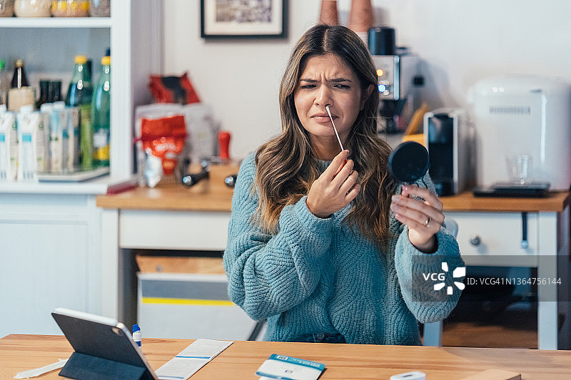 年轻女子在家进行COVID-19自测图片素材