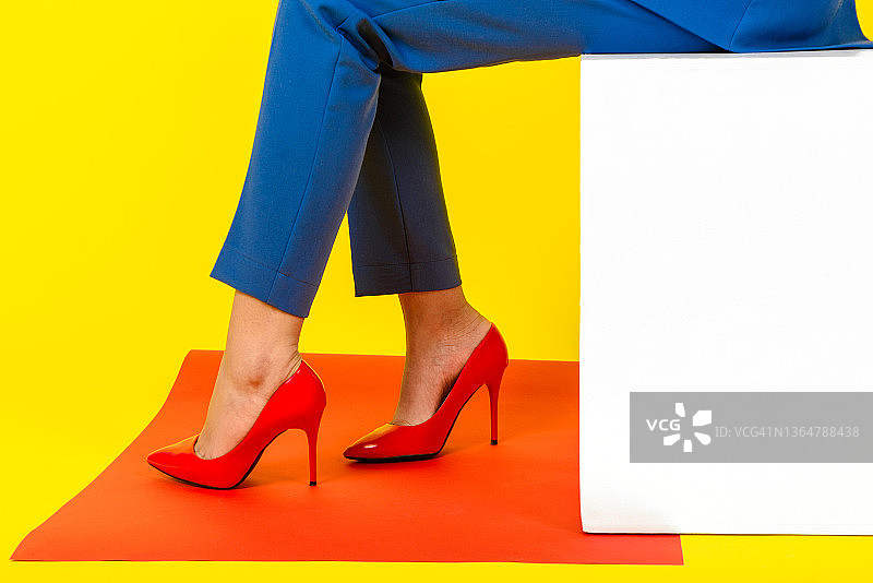 在工作室里穿着红色鞋子的女人的腿，时尚和美容概念图片素材