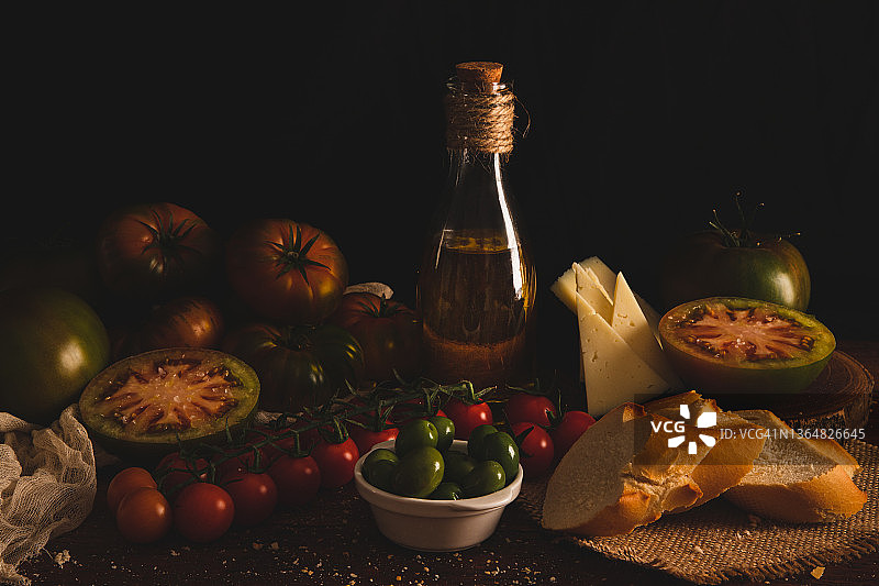 木桌上盛放的各种番茄和橄榄油图片素材