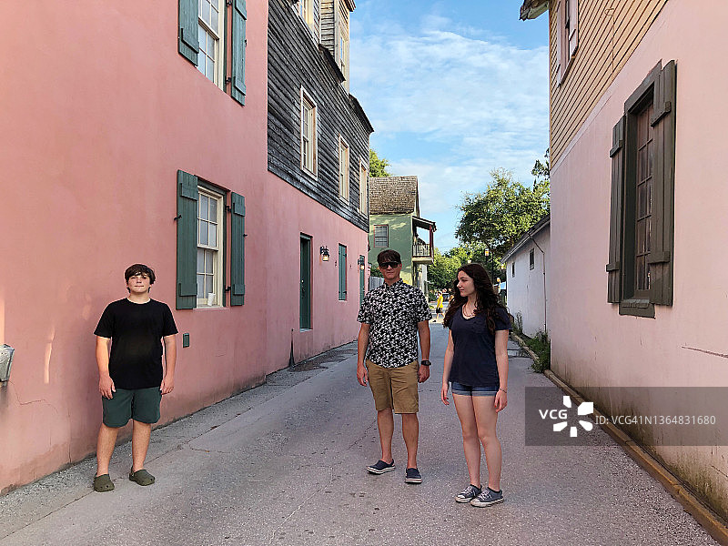 父亲和两个青少年孩子探索圣奥古斯丁历史悠久的狭窄街道图片素材