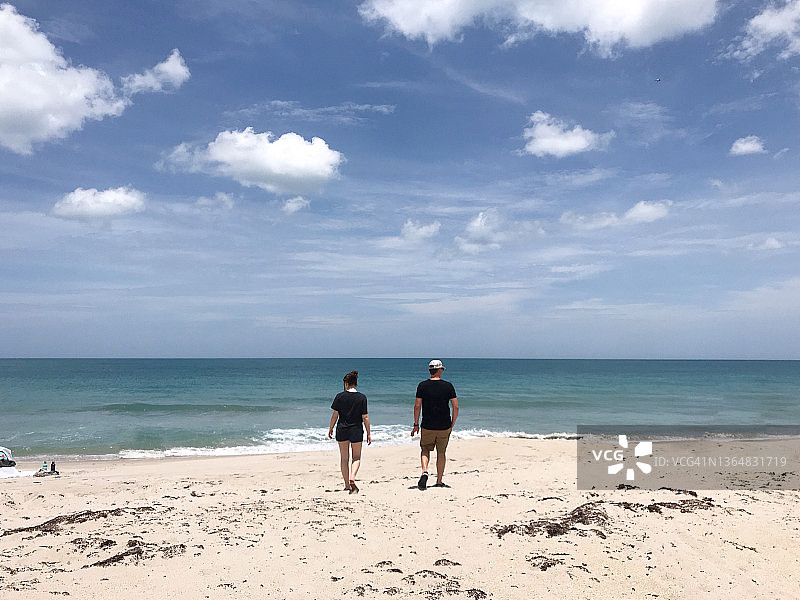 阳光明媚的日子里，少女和父亲走向大海图片素材