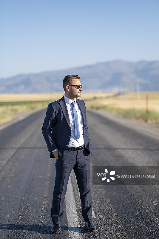 站在路上，遥望远山方向的商人图片素材