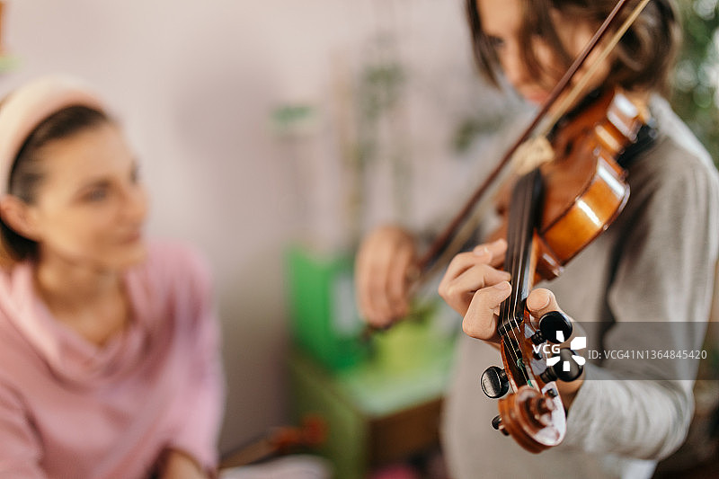 男孩在家跟老师学习拉小提琴图片素材