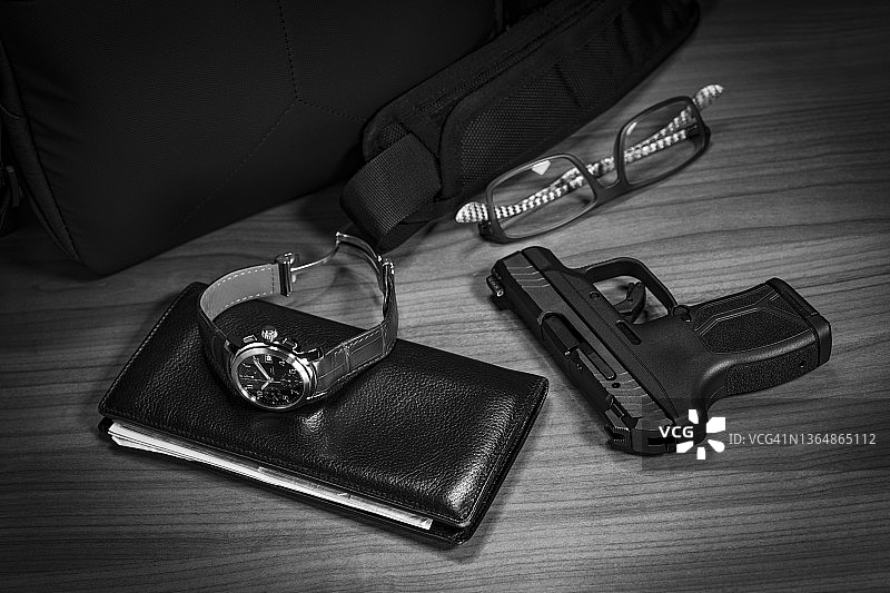 桌上的手枪、钱包、手表和眼镜图片素材