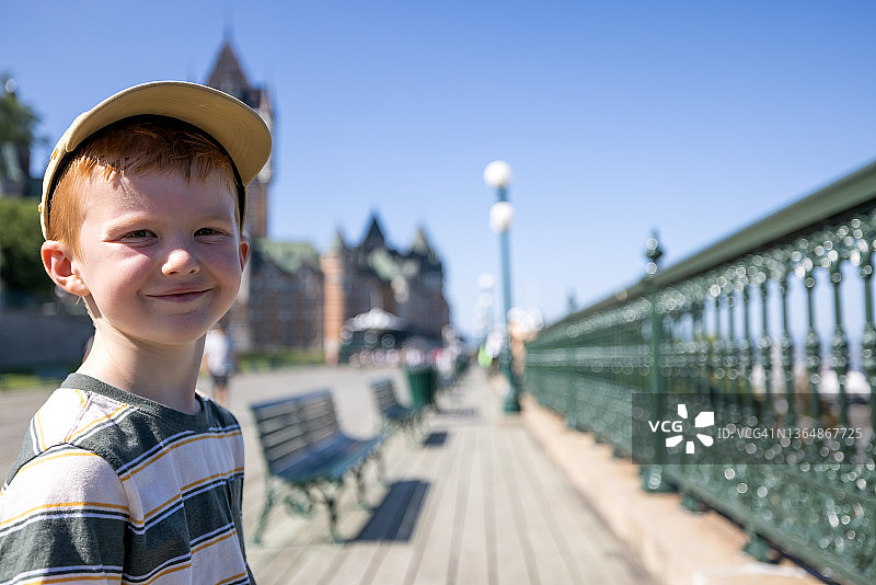 坐在加拿大魁北克市芳堤娜城堡酒店长椅上的可爱红发男孩图片素材