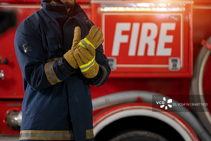 身穿防护服的消防员站在消防车旁图片素材