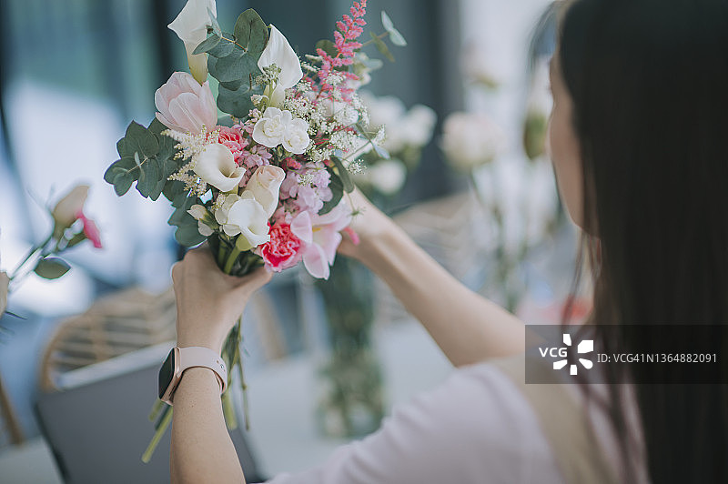 特写：亚洲华人女花艺师在家中厨房整理花束，经营小本生意图片素材
