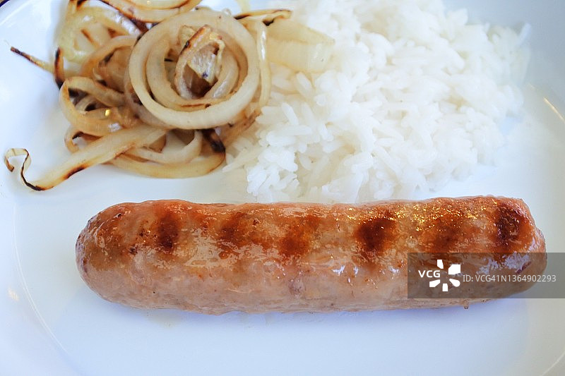 一根煮熟的香肠配炒洋葱和米饭图片素材