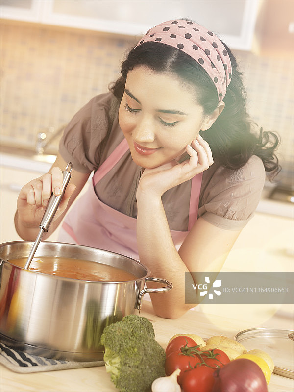 年轻女士在家里厨房做饭图片素材