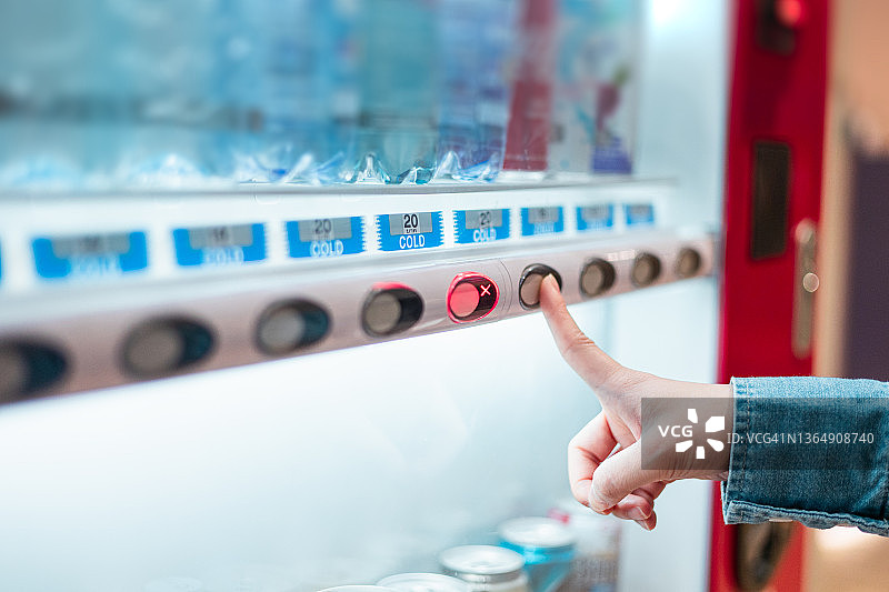 在自动售货机购买清凉饮料的女子局部特写图片素材