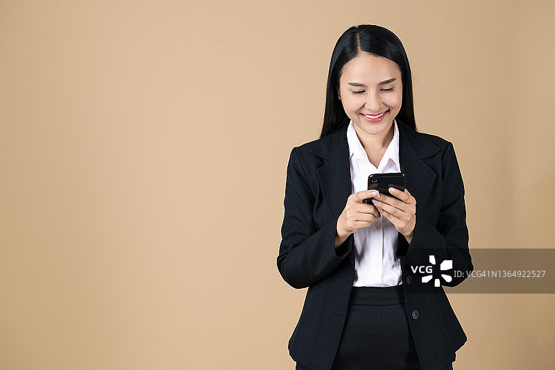 在彩色背景下使用智能手机的女商人肖像图片素材